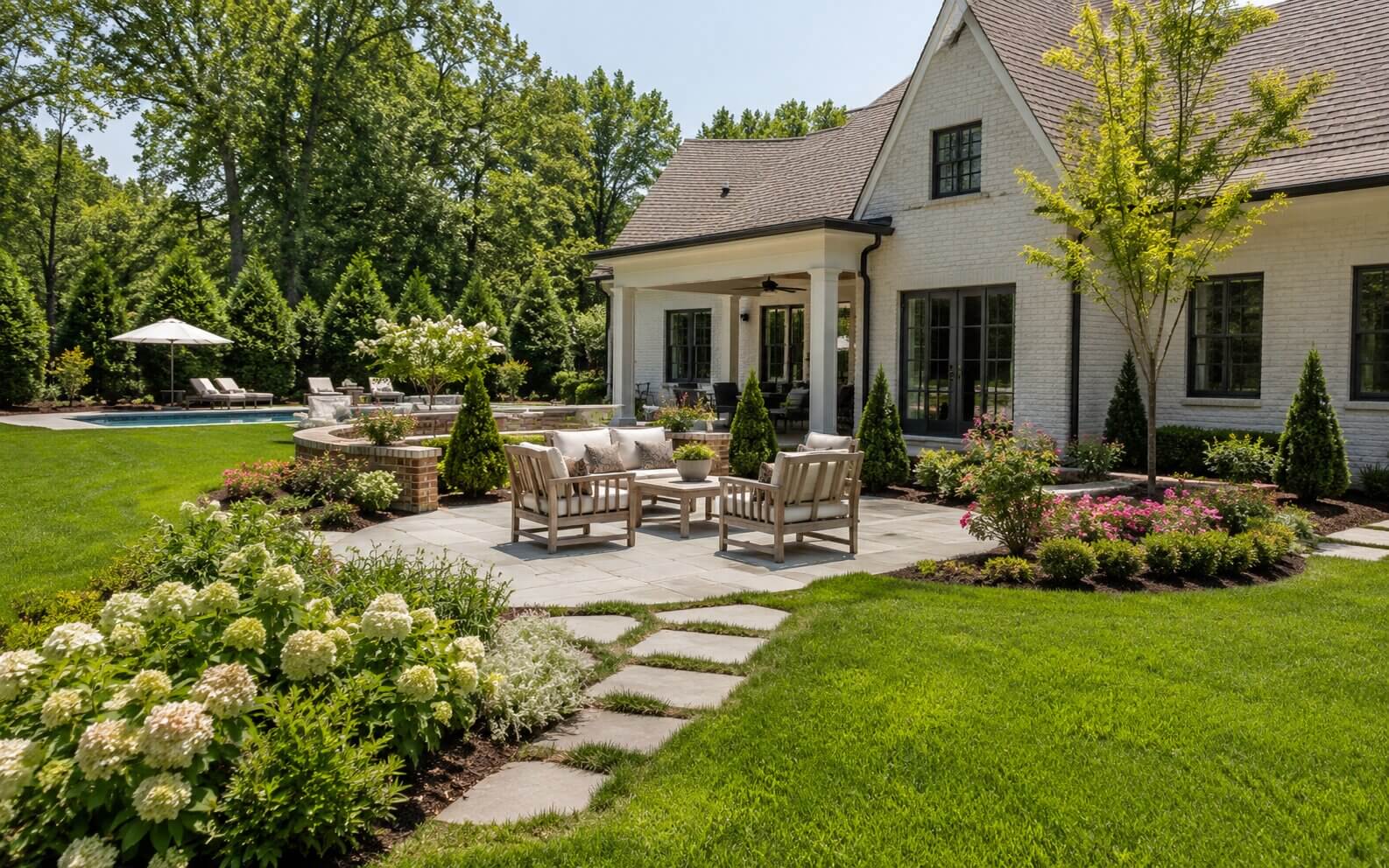 memphis-residential-landscape-design-outdoor-living Residential backyard patio with lawn, garden beds, and outdoor seating at a Memphis-area home
